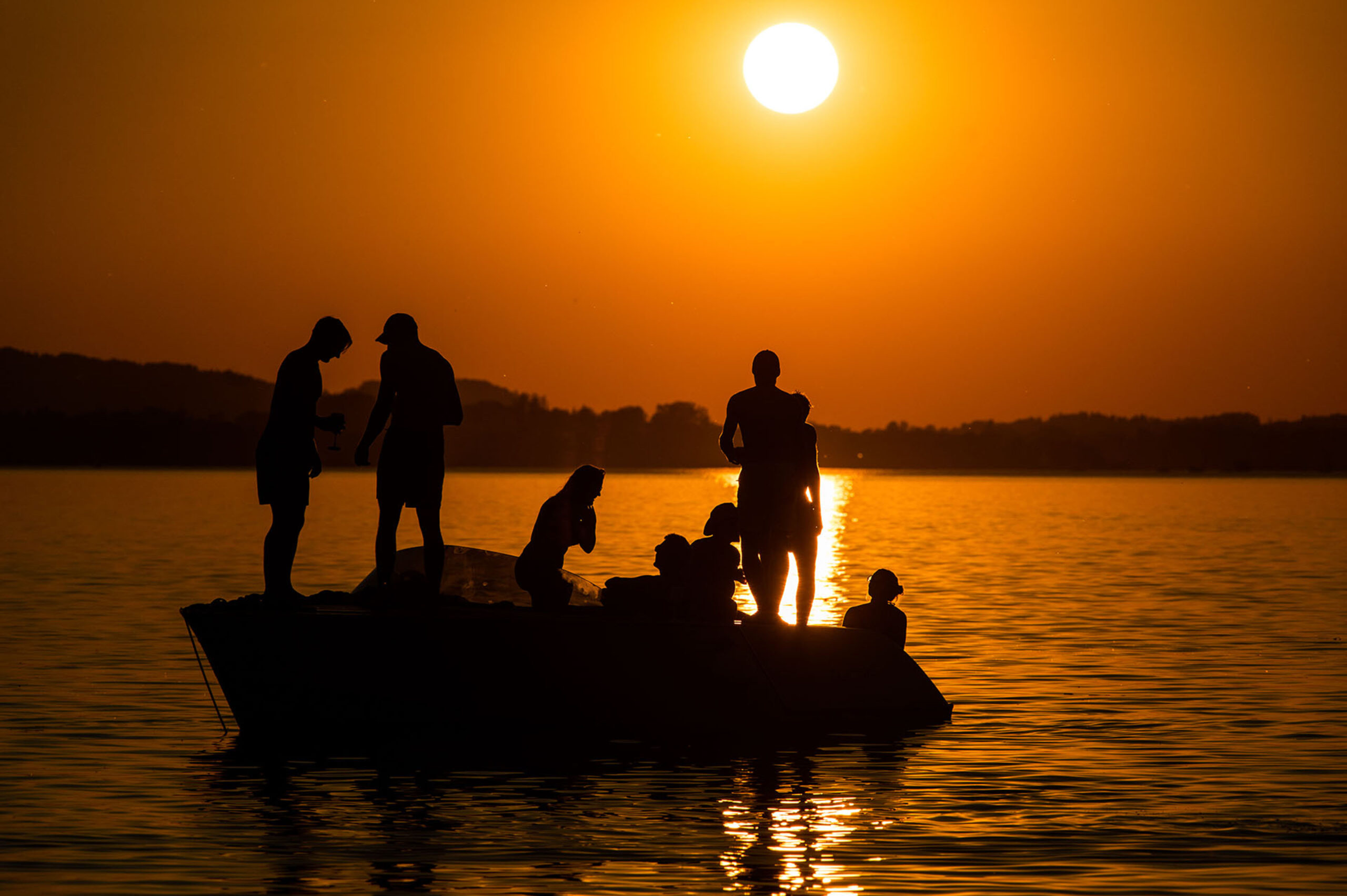 Segelboot bei Sonnenuntergang auf ruhigem Wasser